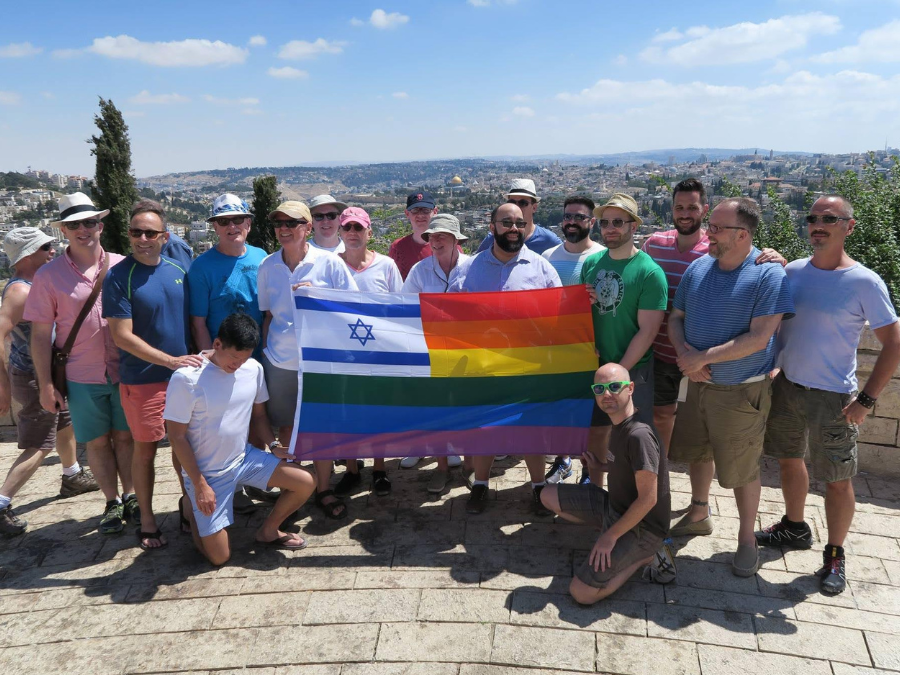 Men standing around a rainbow flag with the Star of David in Israel