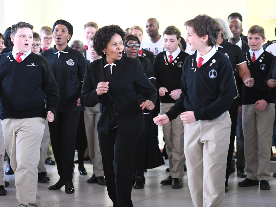 A Black woman dancing and signing with a white teenage boy