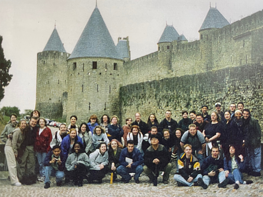 A group of people gathered in front of a castle while sightseeing