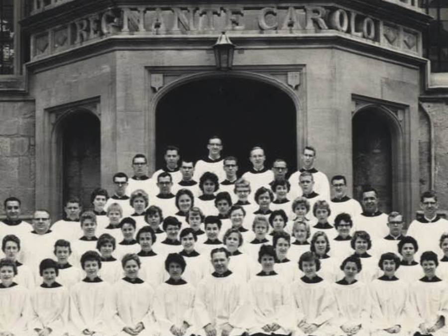 A group of choral singers gathered in front of a church