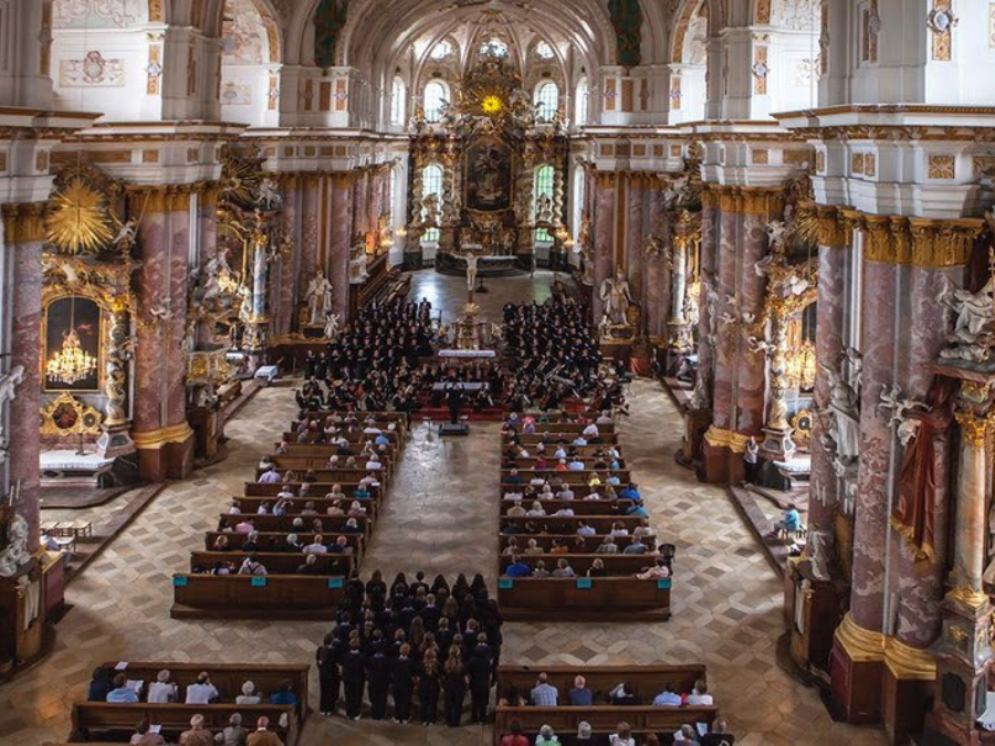 A cathedral with a full audience listening to a choir performing in Germany