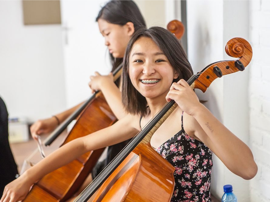 Girl smiling while playing a cello