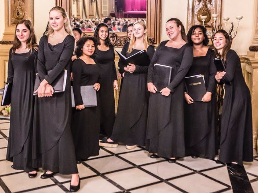 Girls in black dresses holding choral folders