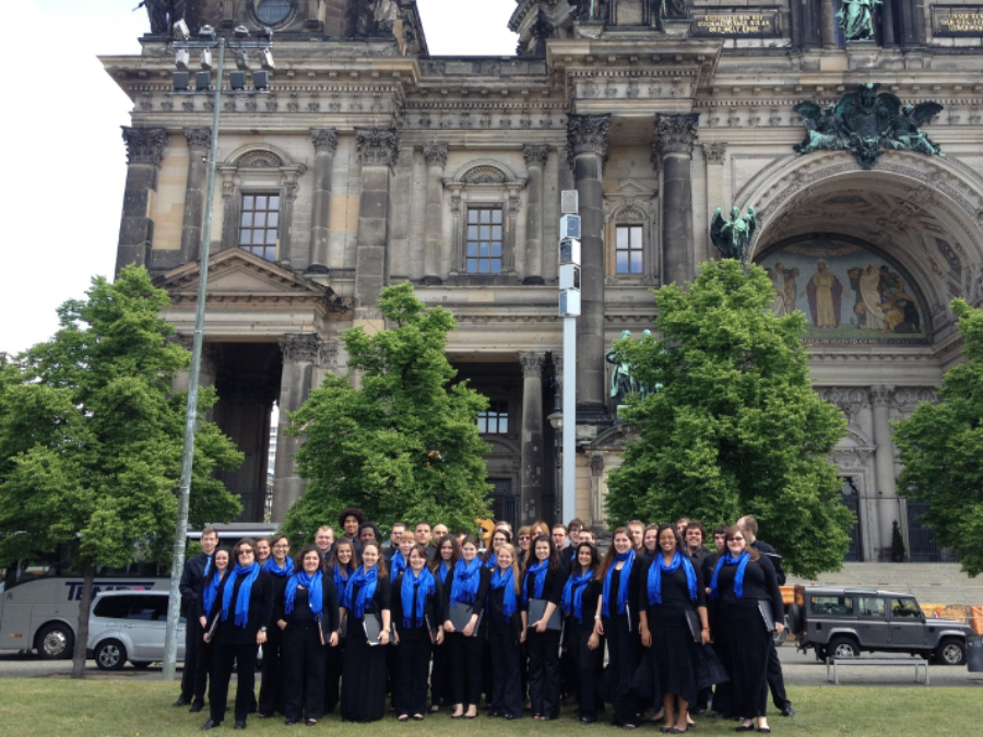 A group of college students dressed in black with blue scarves standing in front of the Dom in Berlin